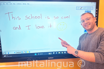 Student angličtiny, který právě napsal sprívně vzkaz na tabuli.