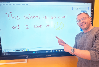 Student angličtiny, který právě napsal sprívně vzkaz na tabuli.