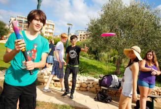 Studenti hrají baseball a frisbee v parku vedle rezidence